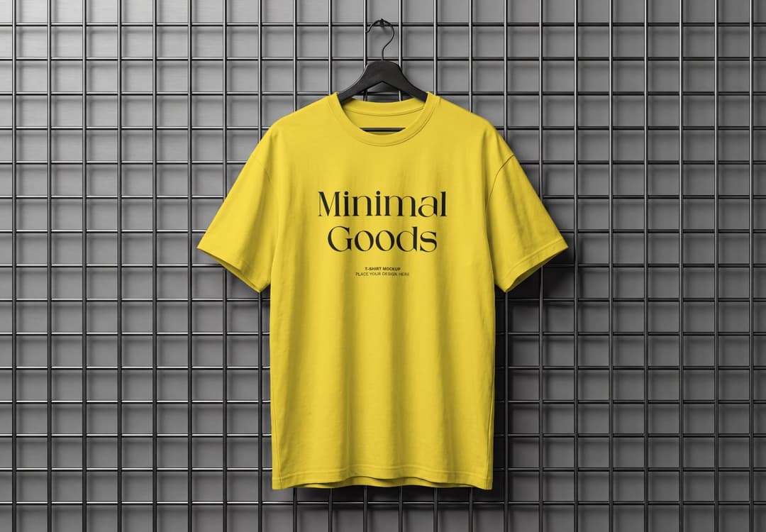 Yellow T-Shirt Mockup Hanging on Black Hanger and Metal Grid Wall