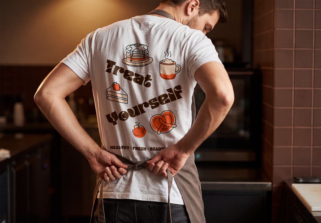 White Graphic Tee Mockup with Apron and Warm Cafe Lighting